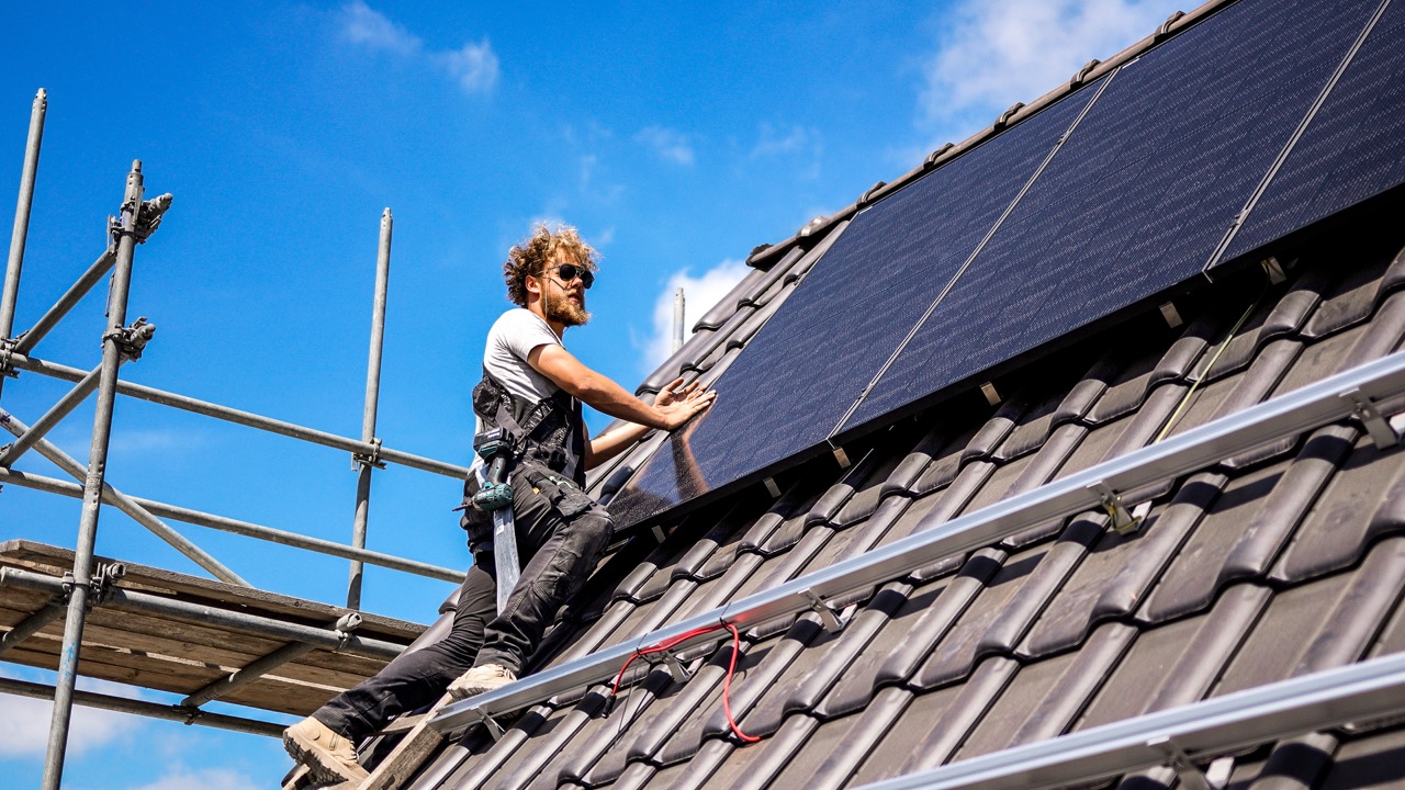 Monteur van Sunforce installeert zonnepanelen op een dak